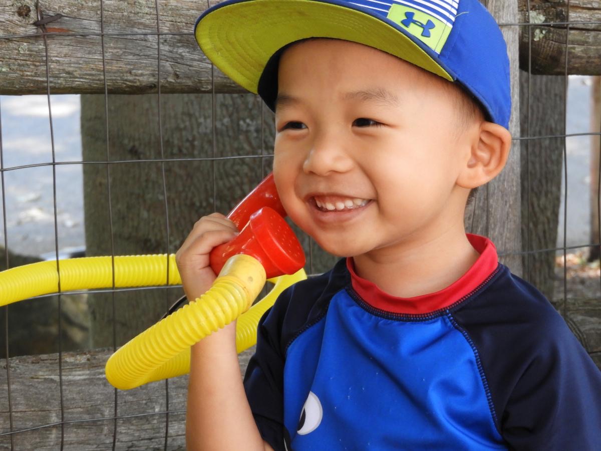 A preschooler grinning during free play in an LPC classroom in Lexington, MA